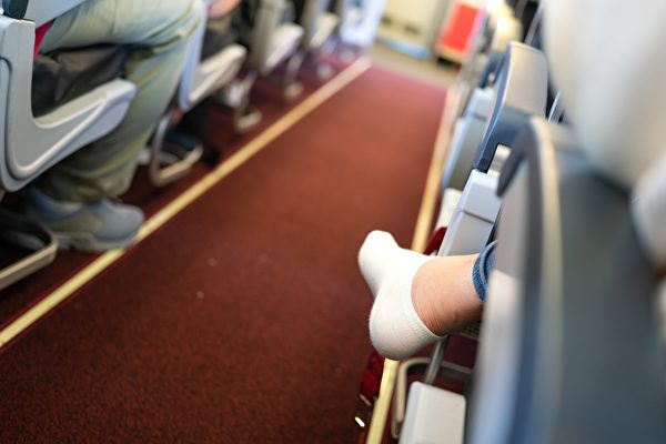 一名飛機乘客脫掉了鞋子。（Shutterstock）
