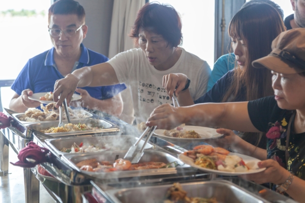 一群越南遊客在遊輪上吃自助餐。（Shutterstock）